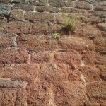 An old wall in Exeter, made of old worn red bricks.