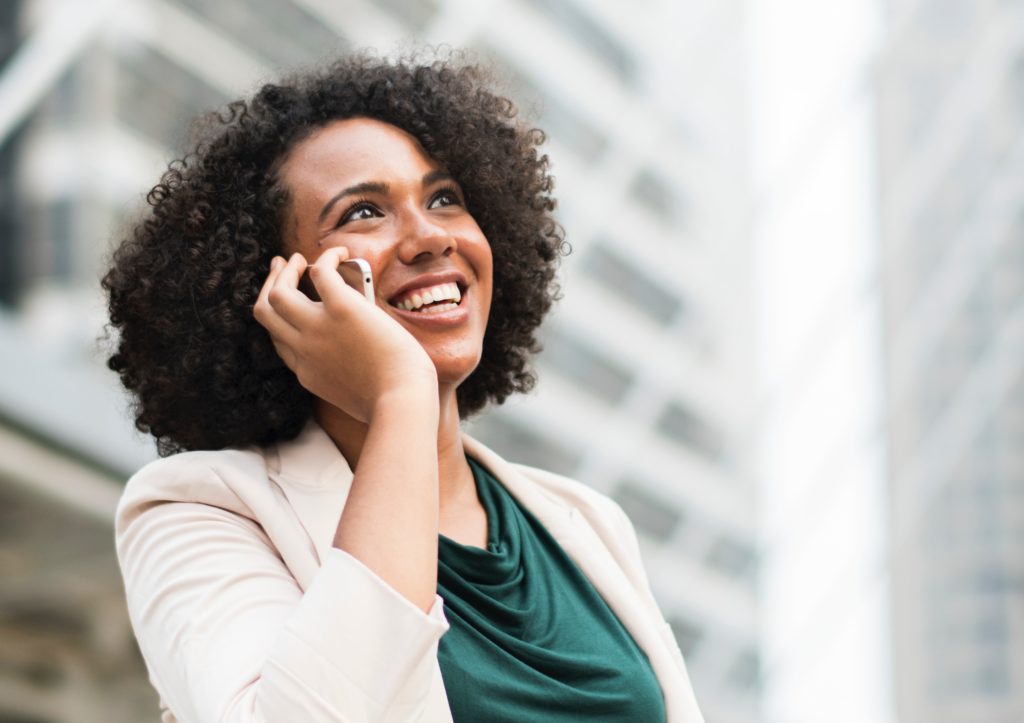 Woman on the phone, grinning.